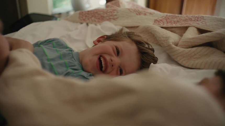 A portrait of child and mother laying in bed