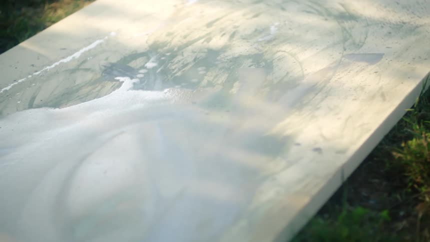 Pale foam covers lower portion of panel resting on grass