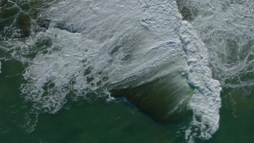 Wave rolling over flat wedge of land foams