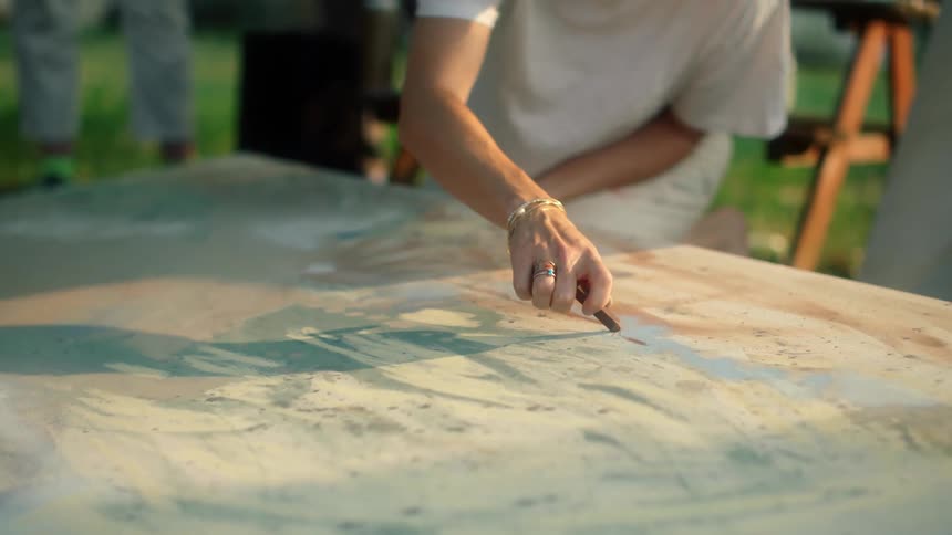 A woman is painting on the canvas