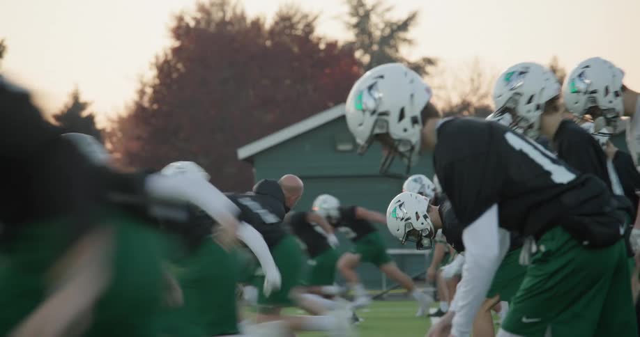 A football team practices running drills