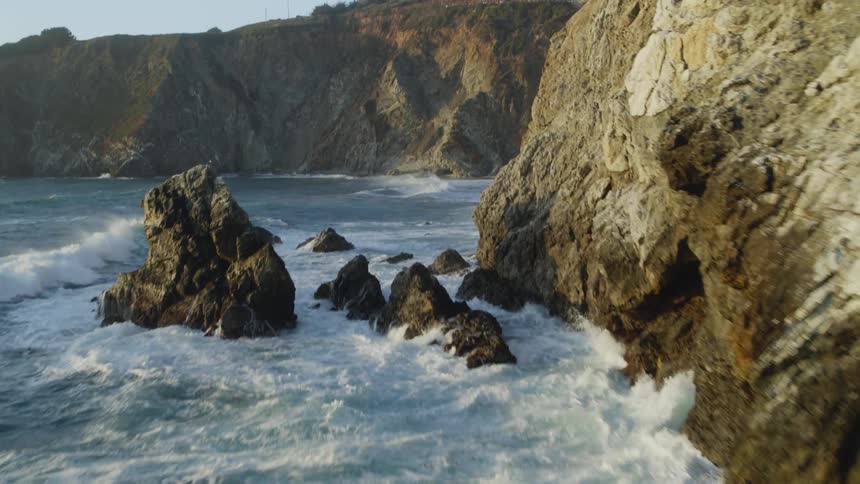 Big Sur Aerial of Waves crashing tilting up to bridge