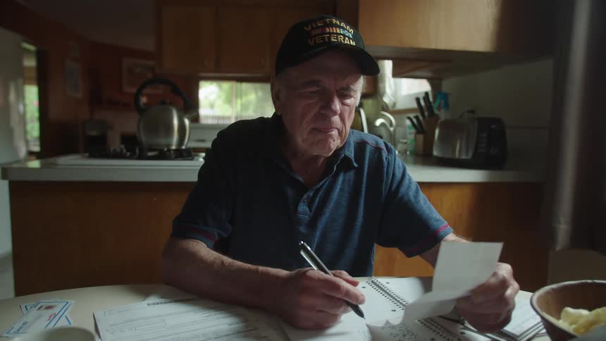 A man makes handwritten records of paper receipts