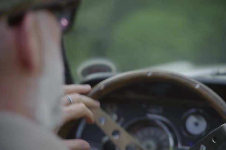 A man is turning the steering wheel as he drives