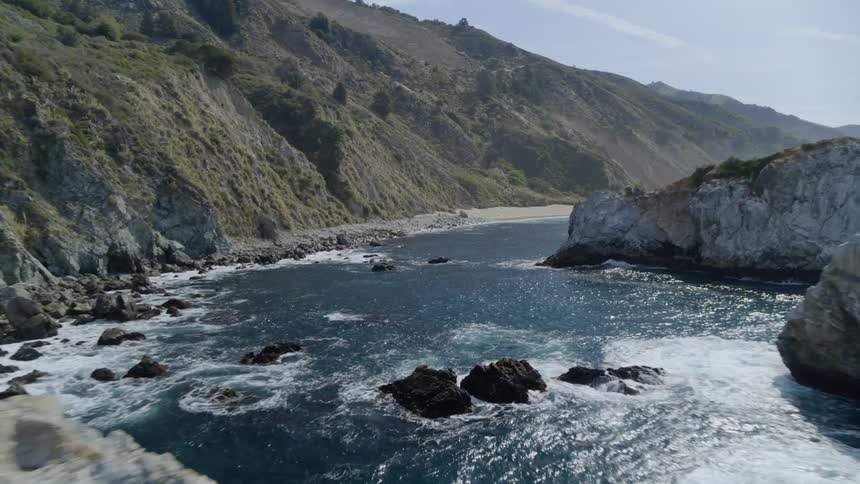Waves swirl between seaside cliffs and rock outcroppings