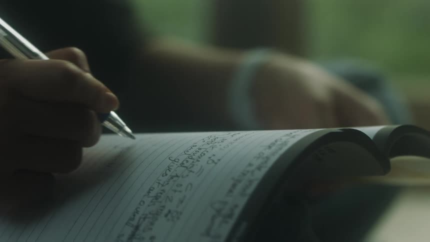 A person writing down some things in a notebook