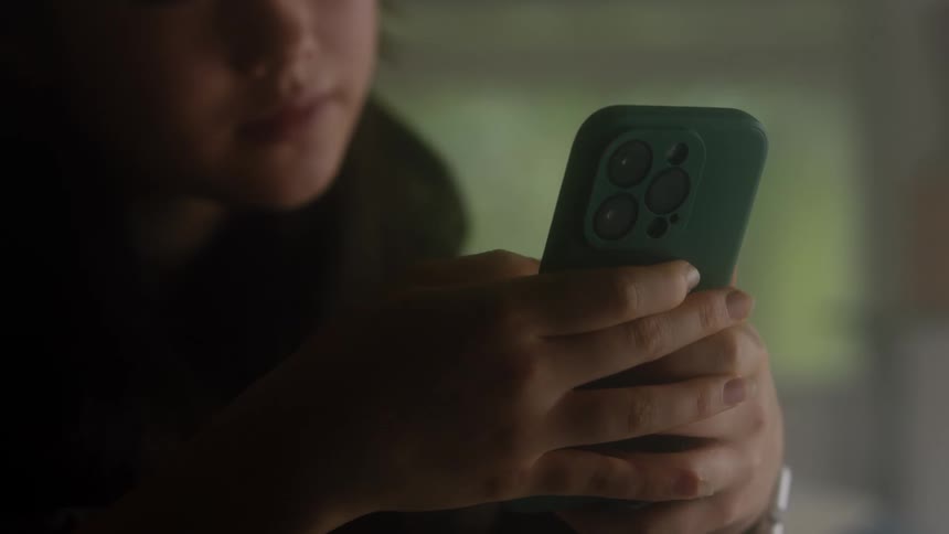 Woman scrolls smartphone and considers screen