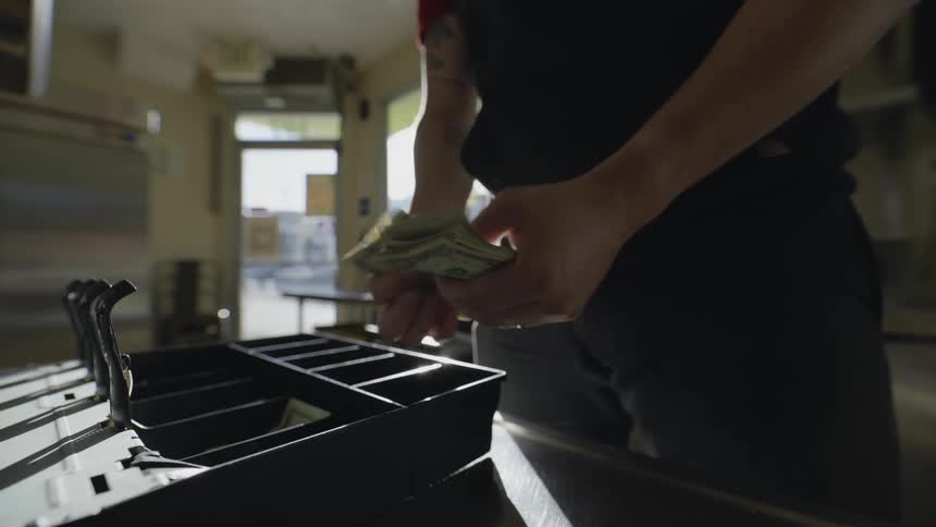 A man counting money in a restaurant