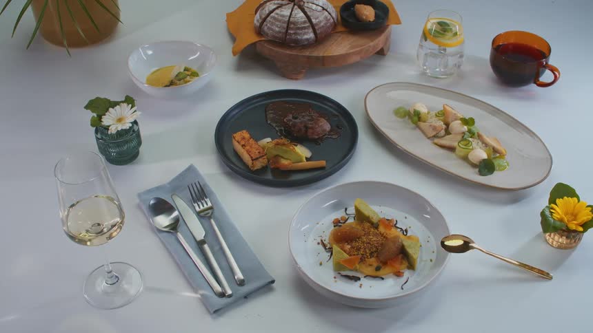 Woman places another plated meal to present food in a studio