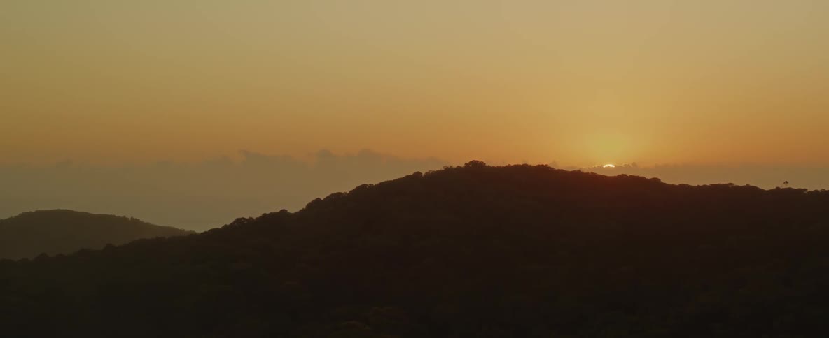 The sun is rising behind the mountain