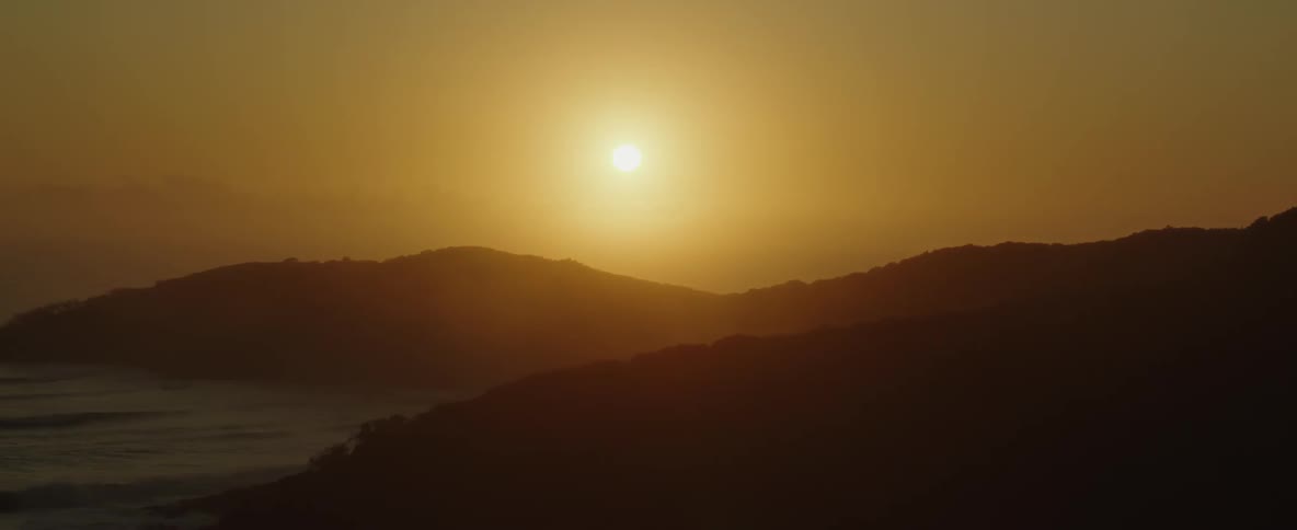 Ocean waves rolling and splashing under a golden sky