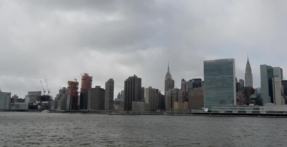Low, gray clouds hovering over a large city and harbor