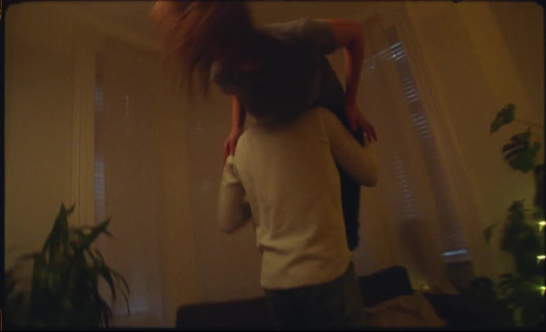 A man picks up his girlfriend throws her over his shoulder and playfully spins her around a few times