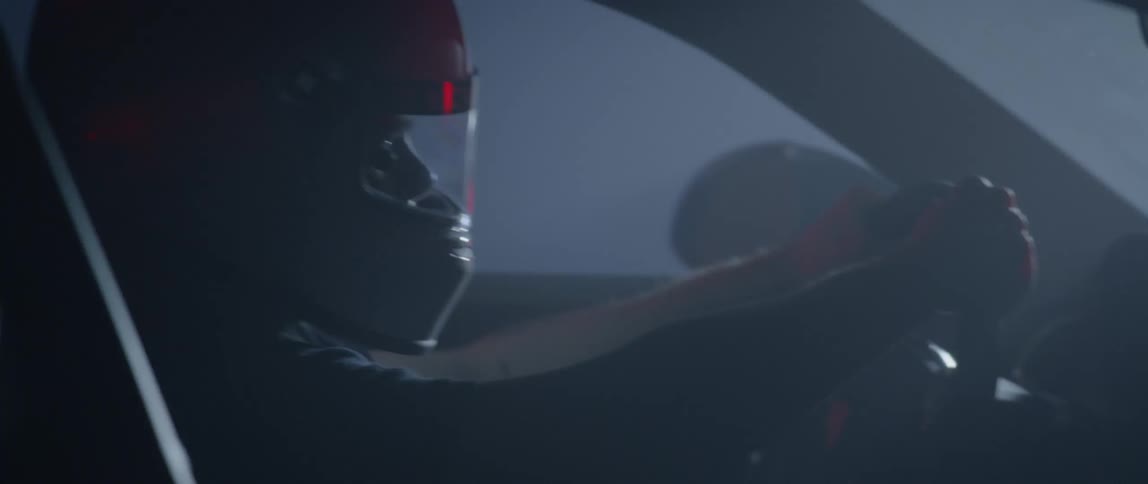 Man wearing crash helmet steers speeding car