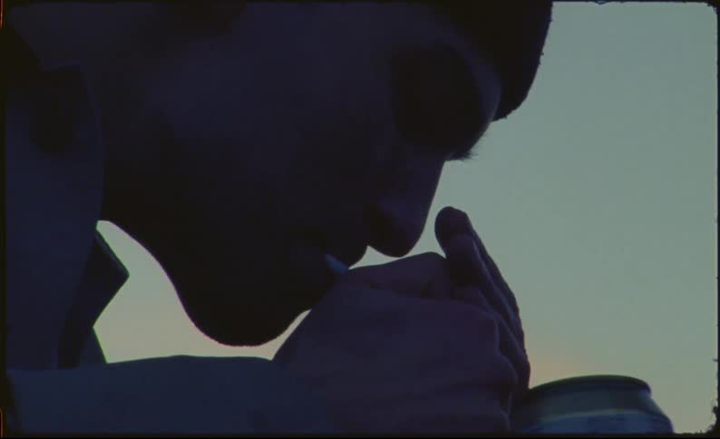 A man and woman kiss and smoke