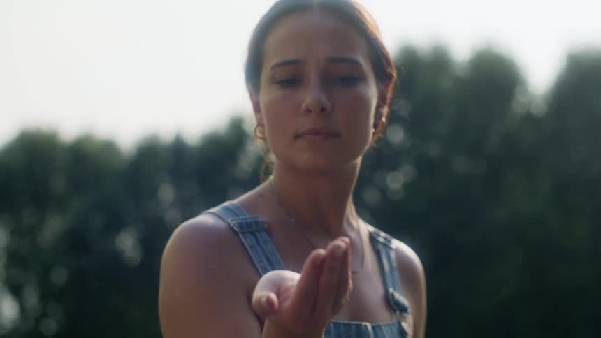 A young woman admiring an insect on her hand