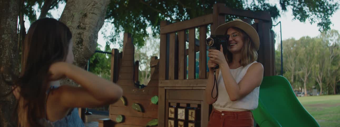 A mother records her daughter jumping and talking with a camera