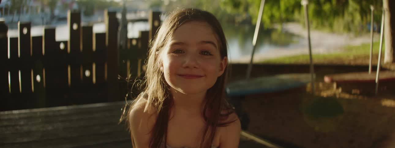 A young girl posing for a photo smiling while in her swimsuit