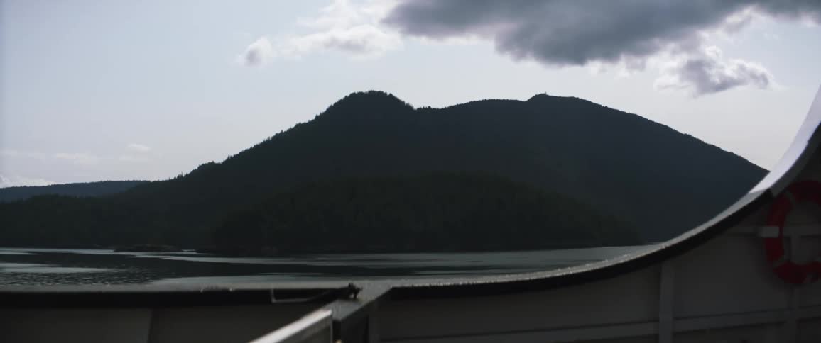 The water and a large hill seen from a boat window