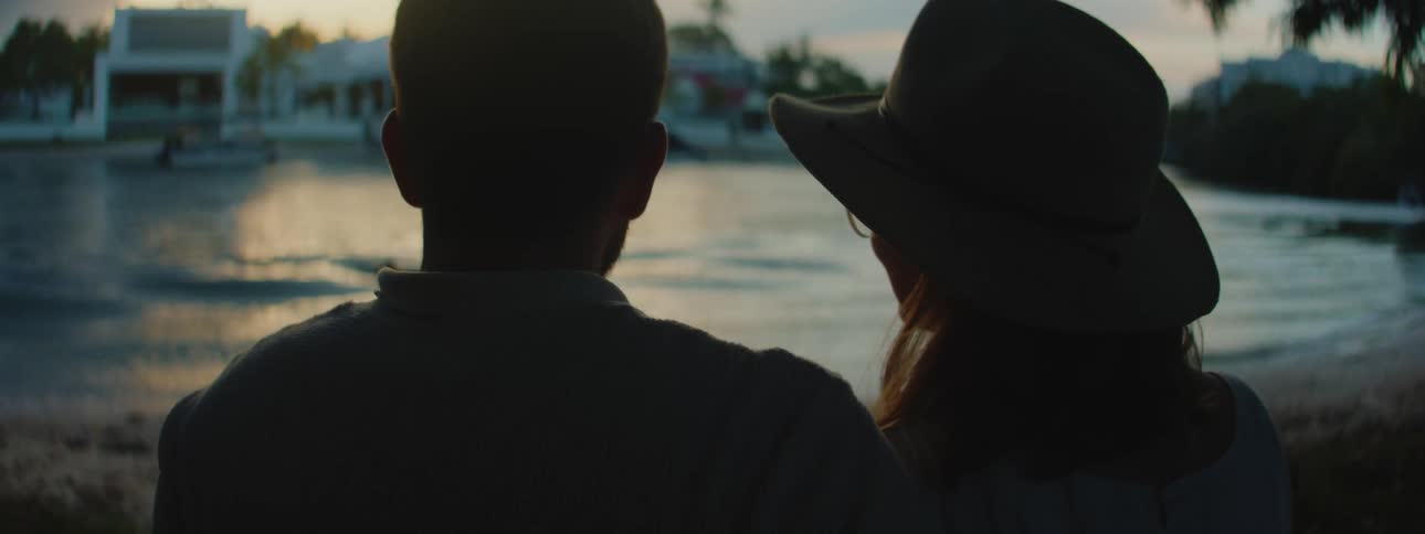 A man and a woman having a romantic moment sitting close to the beach