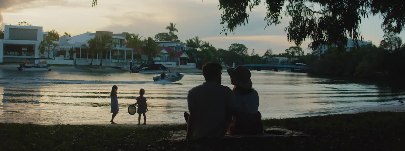 A family relaxing near the edge of a lake