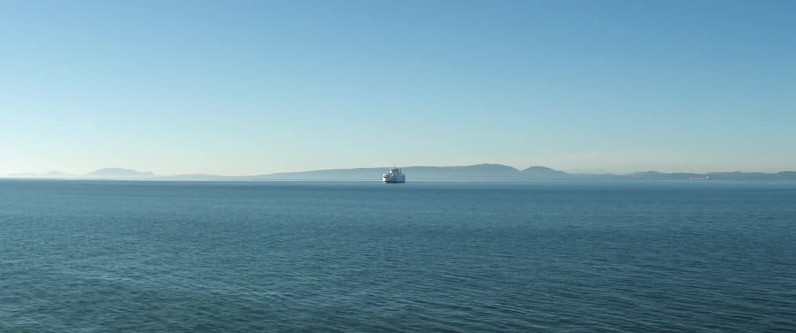 A ship sails on an ocean at dawn