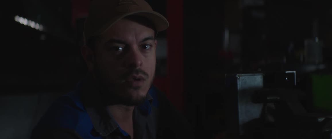 A portrait of a man taking off his glasses