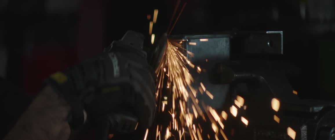 Sparks fly as a welder uses a grinder on metal