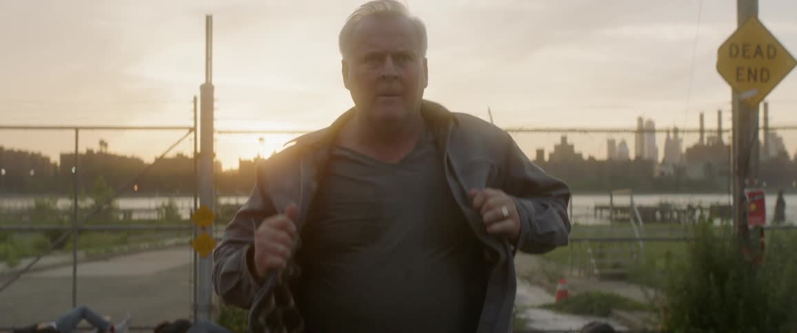 Man adjusts his jacket as he walks outdoors