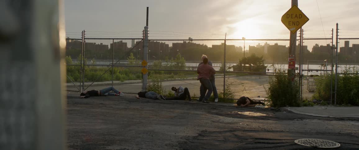 Two men fight outside of a fence