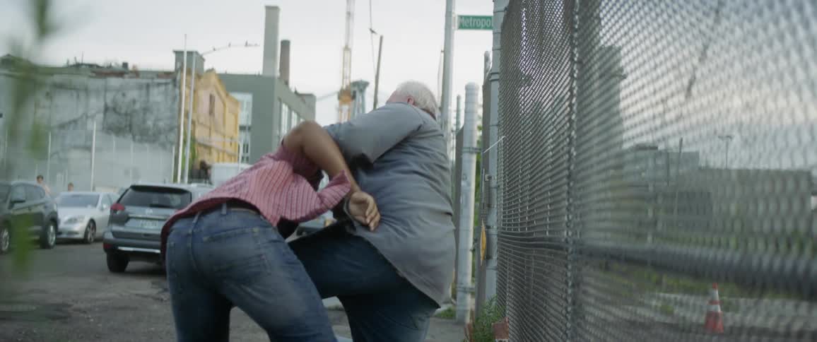 An old man and a young man fight on a city street