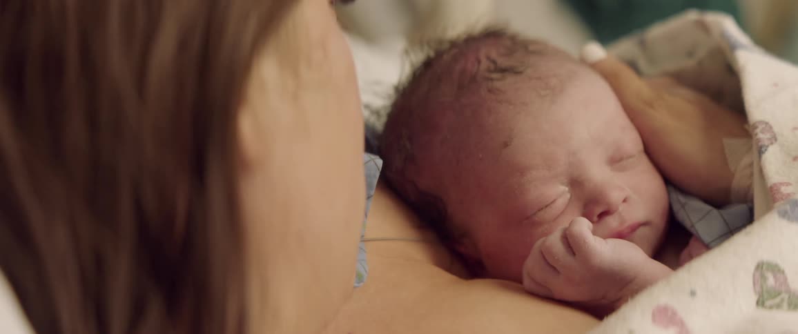 A mother holds a newborn baby to her chest