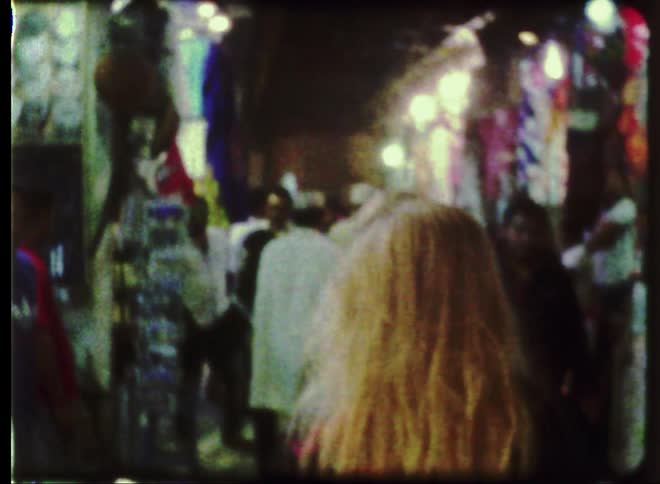Blonde haired woman walking through crowded city