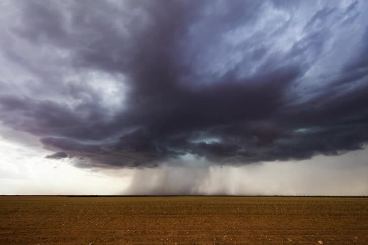 Time lapse of a large storm pouring rain in the distance over a field
