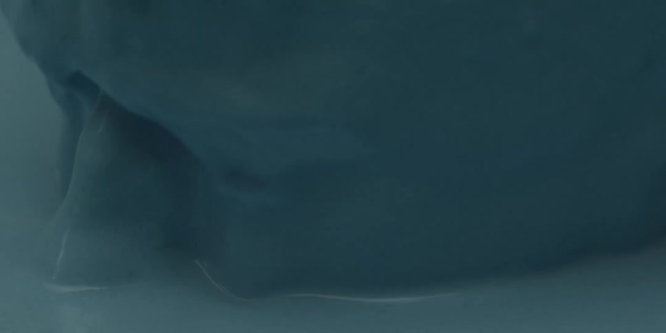 A person emerges from a pool of blue liquid
