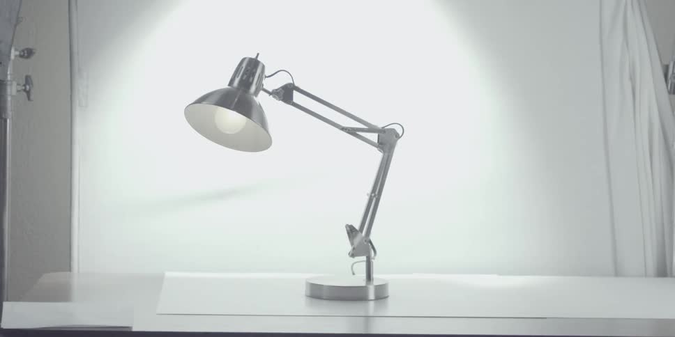 A desk lamp is filmed with a white background