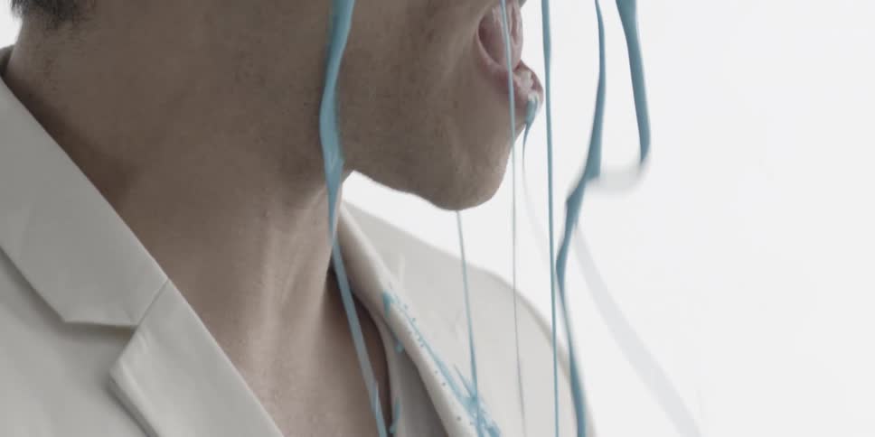 A person is having some sort of thick blue liquid poured over their head
