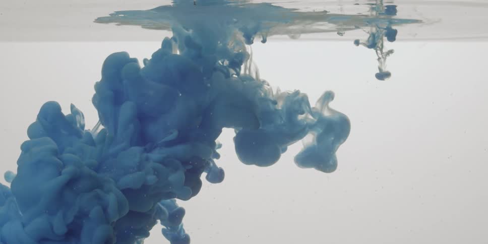Dark blue liquid is dropped into water