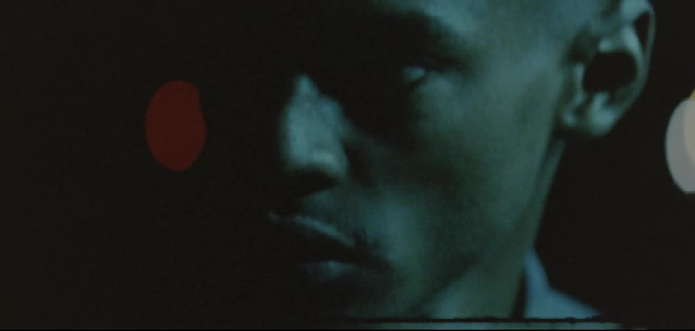 Face of a young black man standing outdoors at night