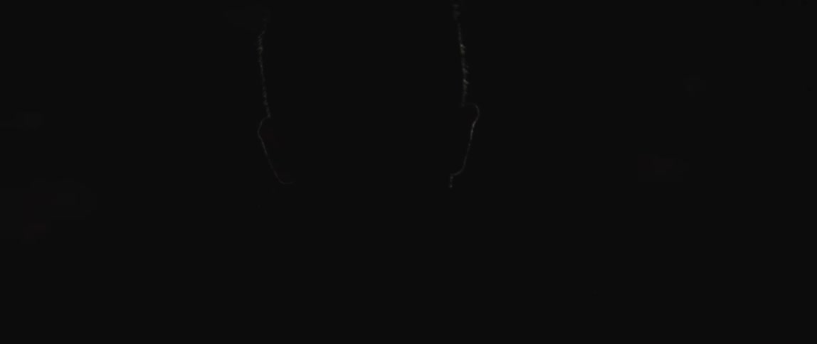A person is in a dark room with a single light
