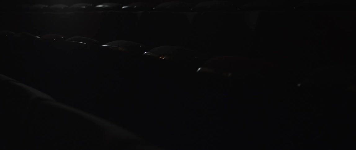 Empty row of seats in a movie theater swiftly being illuminated by a light