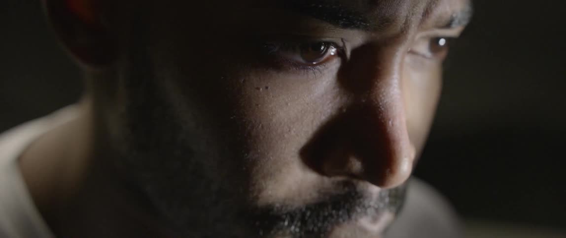 A man looking off in a dark room