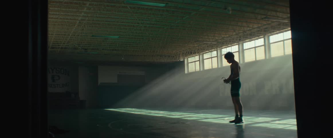 A teenager is standing in the gym