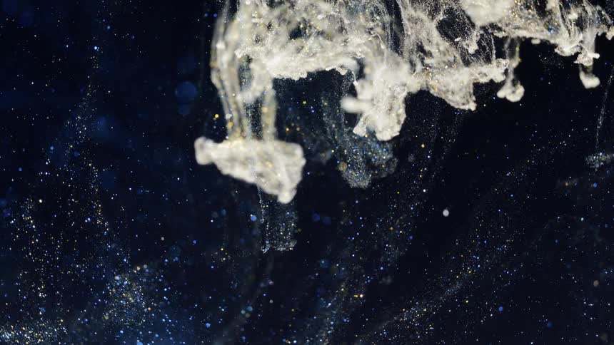 A cloud of white and golden sparkles falls