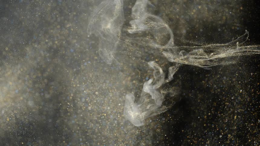 Pale cloud of fine particles floats across dense large particle and light spot filled mixture