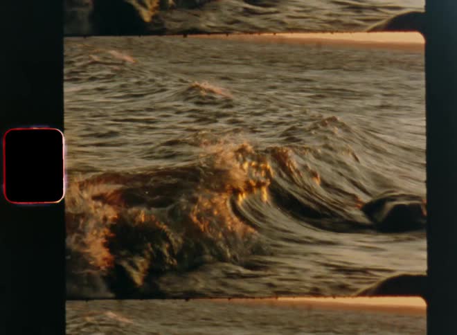 Old vintage film clip of waves crashing and splashing on the beach in a sea bay during golden hour at sunset or sunrise with coastal vibes for summer vacation atmosphere or feeling