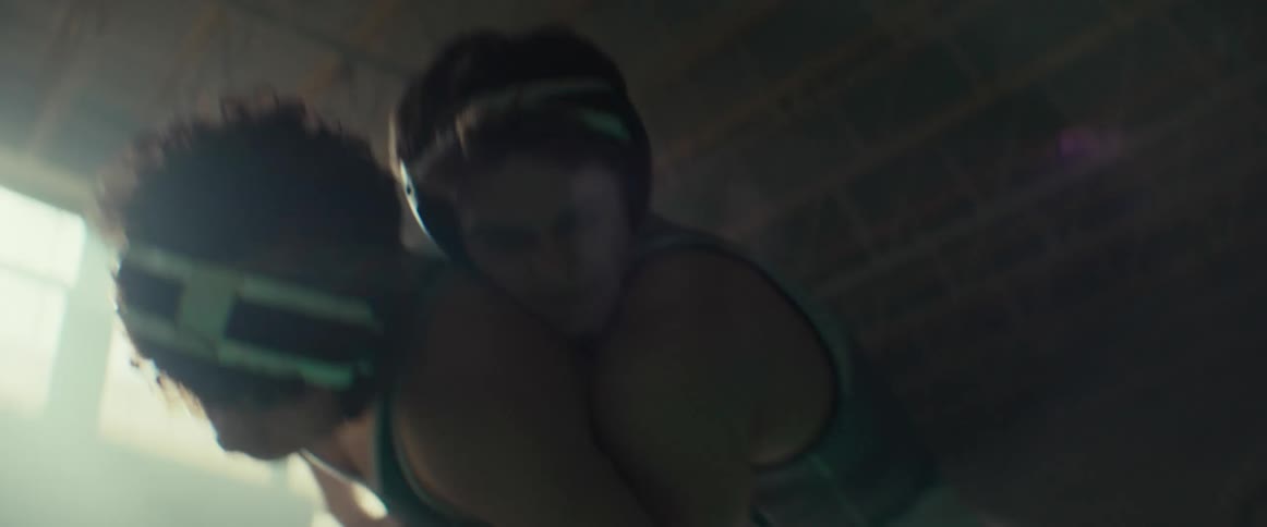 Two wrestlers compete in gym as sun glares into room
