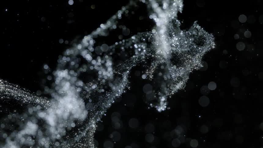 Crystalline particles spray across black background creating white light spots