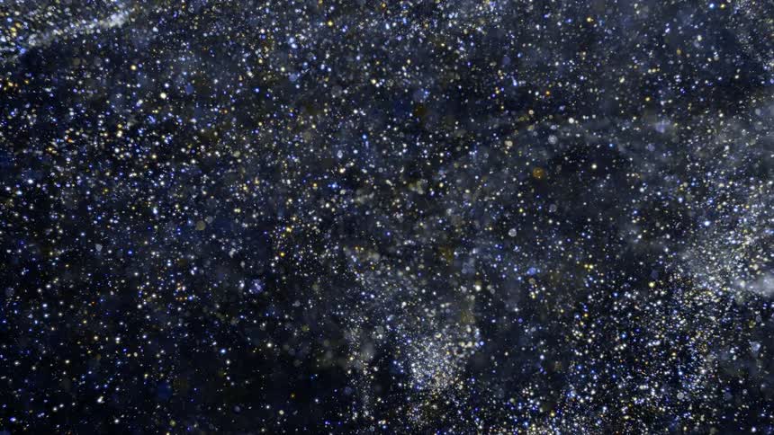 Shiny particles glint and glitter while swirling against black