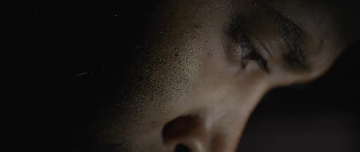 Person in dim room looking downward